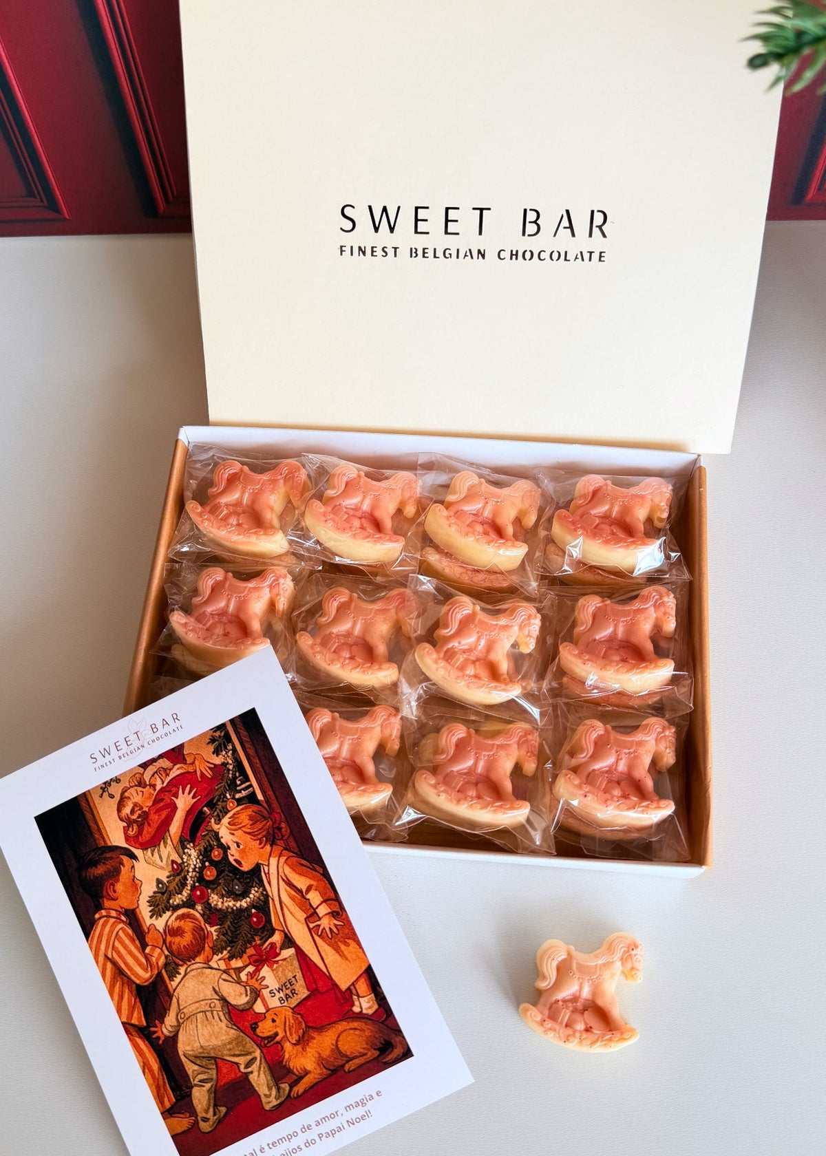 Caixa aberta Sweet Bar com mini cavalinhos de balanço de chocolate branco